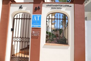 A gated entrance to a building with a sign indicating it's a holiday rental. - 2B Apartamentos Latin (Nerja)