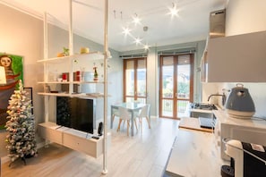 A modern kitchen with a dining area, a white Christmas tree, and a large window with a view. - Fabio's Guest House & Parking (Firenze)