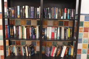 Een boekenplank met verschillende boeken, waarvan sommigen titels en auteurs hebben.