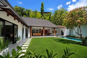 A modern house with a swimming pool, a covered patio, and a well-maintained lawn. - 3BR New Luxury Villa Jimbaran/Nusa Dua (Badung)