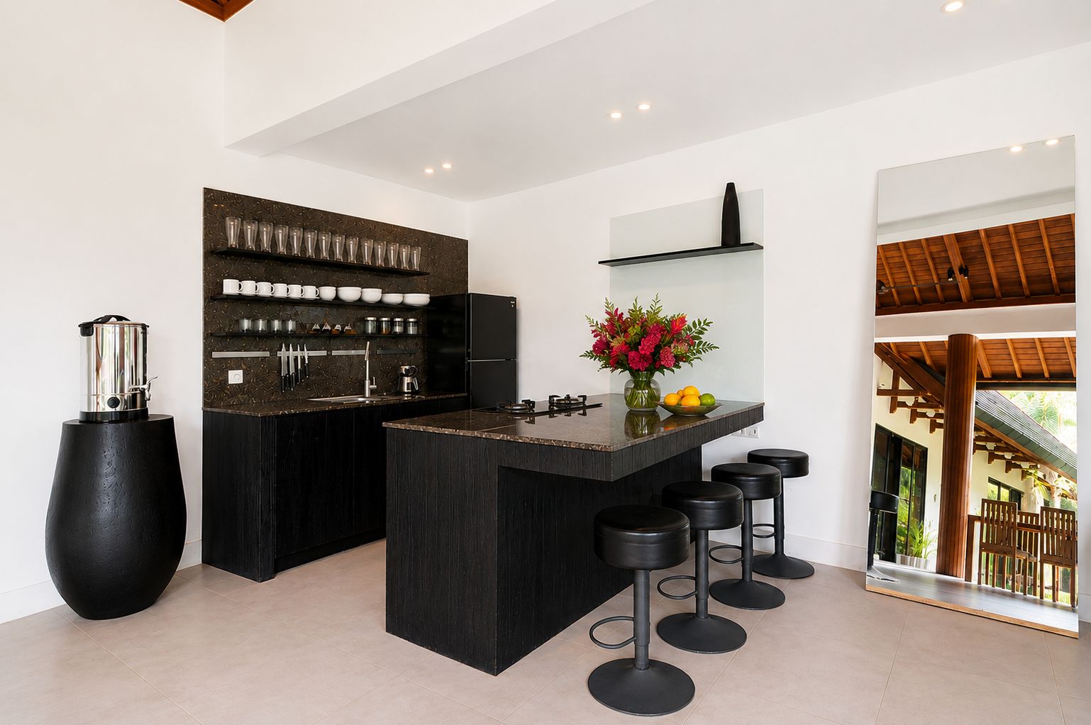 A modern kitchen with a central island, bar stools, and a coffee machine.