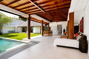 A modern interior with a pool, a dining area, and a living space with a sofa and a coffee table. - 3BR New Luxury Villa Jimbaran/Nusa Dua (Badung)
