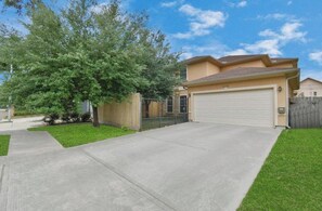 A residential house with a garage, a driveway, and a large tree in the front yard. - Sublet 1 room upstairs located in Houston, Texas. (Houston)