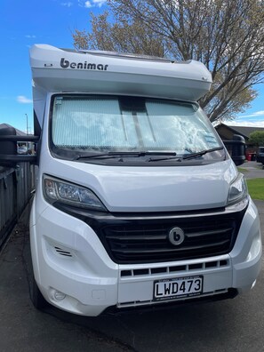 A white camper van with a 'benimar' logo, a windshield, and a license plate 'LWD473'. - Amazing self contained motor home. Stays parked. Close to all city amenities. (Palmerston North)