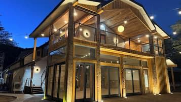 Un bâtiment en bois à deux étages, doté de grandes fenêtres et d’un balcon.