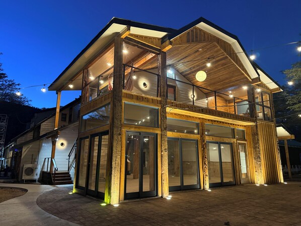 A two-story wooden building with large windows and a balcony.