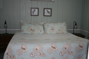 A bedroom with a bed, two nightstands, and two wall-mounted lamps. - Lovely Waterfront Cottage #1821, private patio, overlooking river. Ruskin, FL (Ruskin)