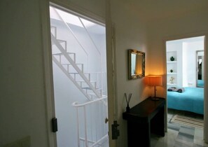 A staircase leading to a bedroom with a bed, a mirror, and a lamp. - Carabeo 78X-2 (Nerja)