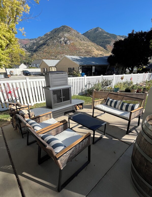 Eine Außenpatio mit Grill, Lounge-Stühlen und Blick auf die Berge.