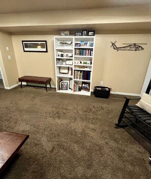 A living room with a bookshelf, a bench, and a sofa. - Newly Renovated Mountain View In-Law Apartment (North Ogden)