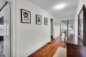 Bright upstairs landing with vintage art, wood floors, and classic stairs - Downtown New Bern 3-Bed Home - Yard, Pet-Friendly! (New Bern)