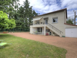 A two-story house with a covered patio, a fenced yard, and a garage. - Cosy gîte with garden, pets allowed (Commelle-Vernay)