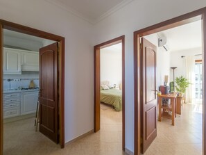 A corridor with wooden doors leading to a kitchen and a bedroom. - Cozy apartment, Eastern Algarve - 4 guests (Tavira)