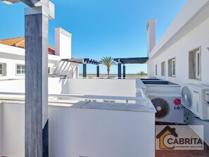 A rooftop terrace with outdoor air conditioning units, a pergola, and a view of the sea. - Duplex apartment with panoramic view - Unknown number of guests (Tavira)