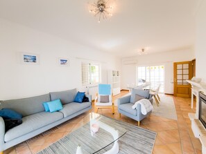 A spacious living area with a sofa, armchairs, a coffee table, and a dining table with chairs. - Villa with private pool and AC - Tavira (Tavira)