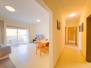 A modern apartment with a dining area, a TV, and a balcony. - Apartment with AC - 4 guests Near beach (Tavira)