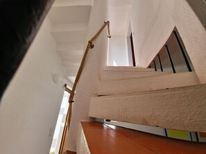 Eine Treppe mit einer strukturierten Wand und einem hölzernen Geländer.