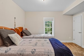 A bedroom with two beds, a window, and a door. - Spacious 6-bedroom house in beautiful Fredericksburg with AC (Fredericksburg)