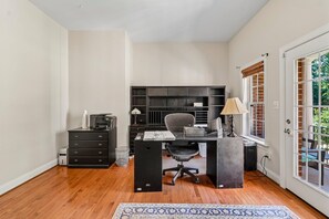A home office with a desk, chair, printer, and shelving. - Spacious 6-bedroom house in beautiful Fredericksburg with AC (Fredericksburg)