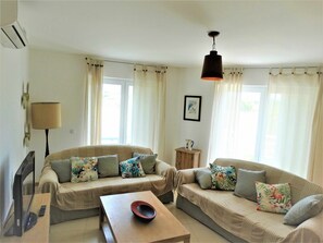 A living room with two sofas, a coffee table, a lamp, and a picture frame on the wall. - Spacious apartment - 5 guests (Tavira)