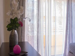 A room with a dark wooden table, a vase with flowers, and a pink spherical object. - 2-bedroom apartment near Tavira (Tavira)