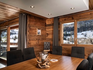 A wooden-paneled room with a large window offering a view of a snowy landscape. - Chalet pets welcome - 8 guests, mountain view (La Clusaz)