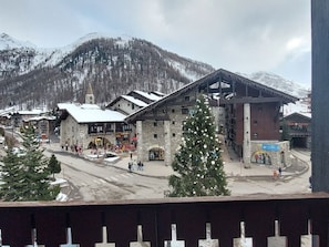A stone building with a ski lift structure, a Christmas tree, and a mountain backdrop. - Central duplex, mountain view - 4 guests (Val-d'Isère)