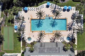 An aerial view of a resort with a large rectangular swimming pool surrounded by palm trees and sun loungers. - New 5BR Reunion Villa, Themed Rooms, Resort Pools (Kissimmee)
