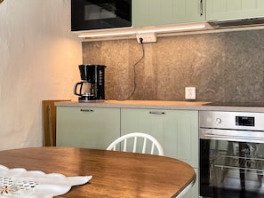 A kitchen with a coffee maker, a microwave, and an oven. - 4 Person Holiday Home in Kopingsvik (Kopingsvik)