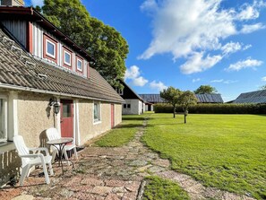 A house with a paved patio, outdoor seating, and a well-maintained lawn. - 4 Person Holiday Home in Kopingsvik (Kopingsvik)