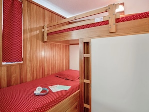 A bunk bed with a red polka dot bedspread, a wooden headboard, and a window with a red curtain. - South-facing studio with balcony - 4 guests (Saint-Chaffrey)