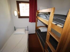 A small, compact room with a bunk bed, a single bed, and a window with curtains. - Apartment pets allowed, 7 guests, piste view (Villarodin-Bourget)