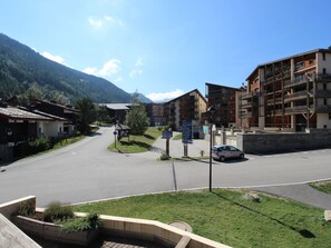 A street view with a parking area, buildings, and a mountainous backdrop. - Apartment pets allowed, 7 guests, piste view (Villarodin-Bourget)