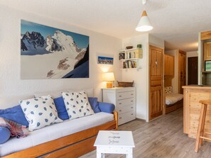 A compact living space with a sofa, a small table, a kitchen area, and a dining table. - Studio, parking, pets welcome - 3 guests (La Salle-les-Alpes)