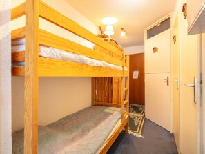 A bunk bed room with a wooden bunk bed, a desk, a chair, and a small window. - Pleasant studio, parking - mountain view (La Salle-les-Alpes)