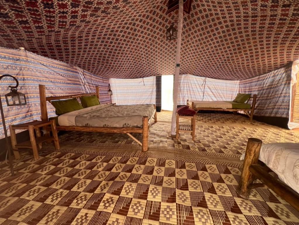 A room with two beds, each with a patterned canopy and a wooden frame.