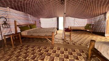 A room with two beds, each with a patterned canopy and a wooden frame.
