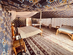 A tent-style room with a bed, two chairs, and patterned walls. - Camp Rêve de Nomade (Lompoul)