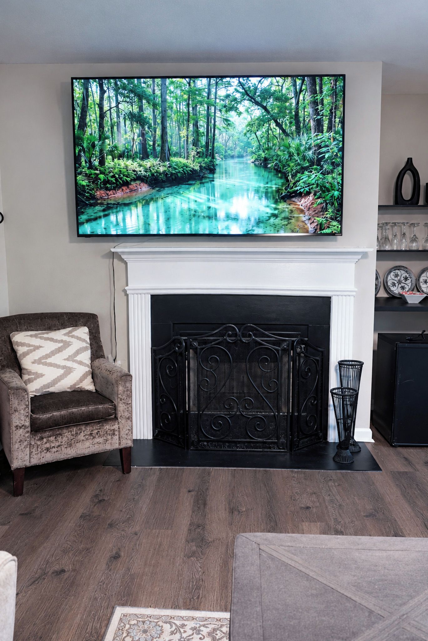 A living room with a fireplace, a television mounted above it, and a sofa.