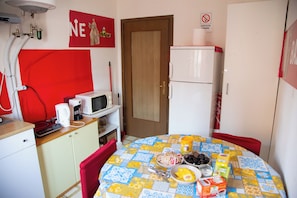 A compact kitchen with a microwave, coffee maker, and a small refrigerator. - Vrbo Property (Venezia)
