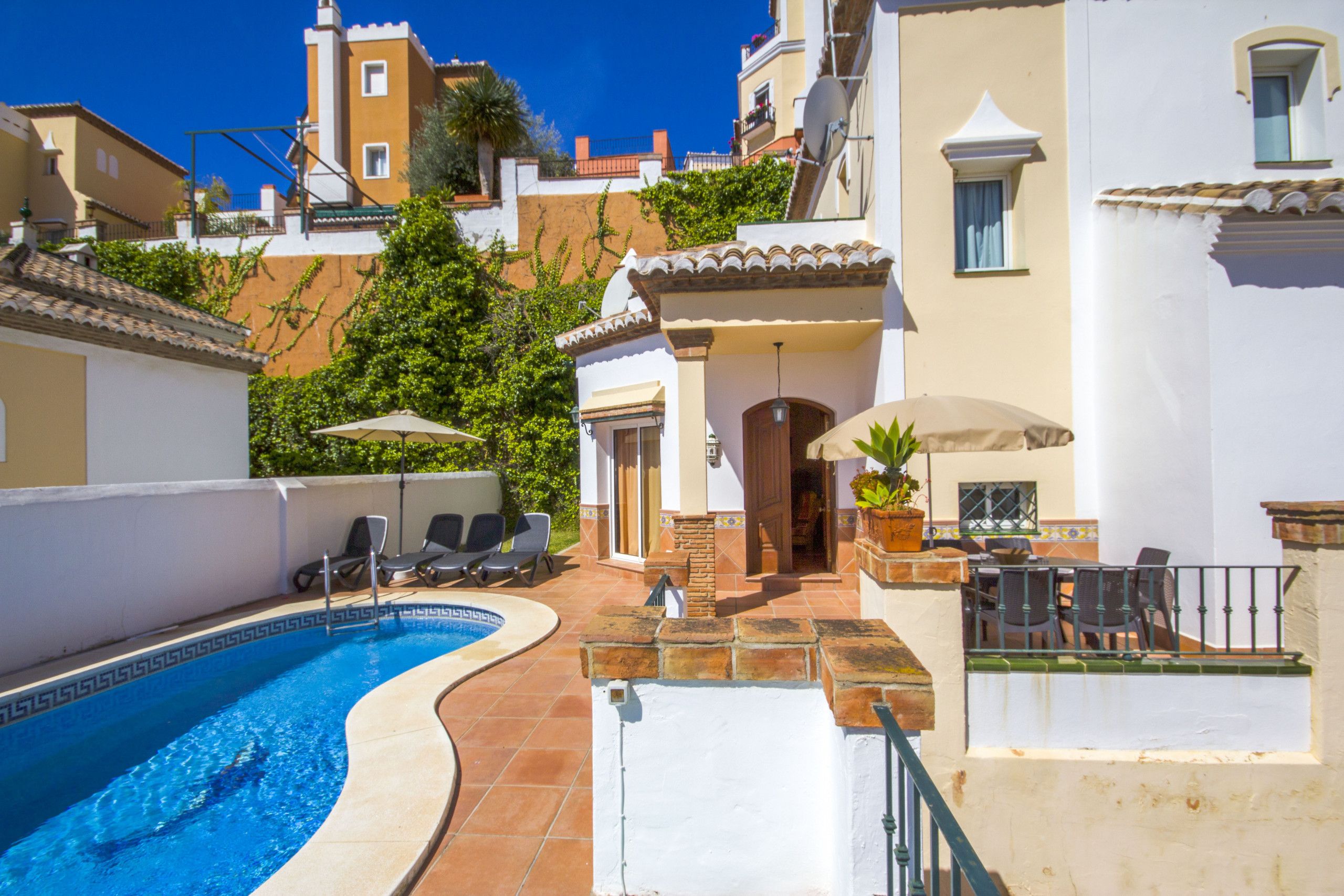A swimming pool with lounge chairs and a patio area.