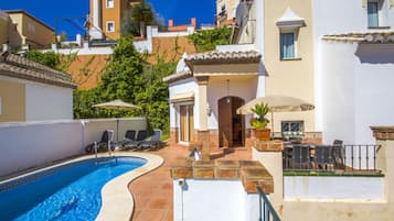 A swimming pool with lounge chairs and a patio area.