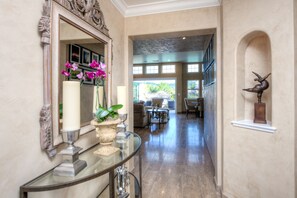 A hallway with a mirror, a glass table with vases, and a statue. - Inviting 4Br/4Ba executive home in desirable Larkspur Creekside neighborhood (Larkspur)