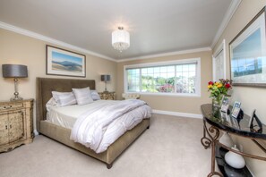 A bedroom with a large bed, a chandelier, a window with a view, and a dresser with a lamp. - Inviting 4Br/4Ba executive home in desirable Larkspur Creekside neighborhood (Larkspur)