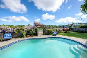 A backyard with a swimming pool, a wooden fence, and a view of a hill with buildings. - Inviting 4Br/4Ba executive home in desirable Larkspur Creekside neighborhood (Larkspur)