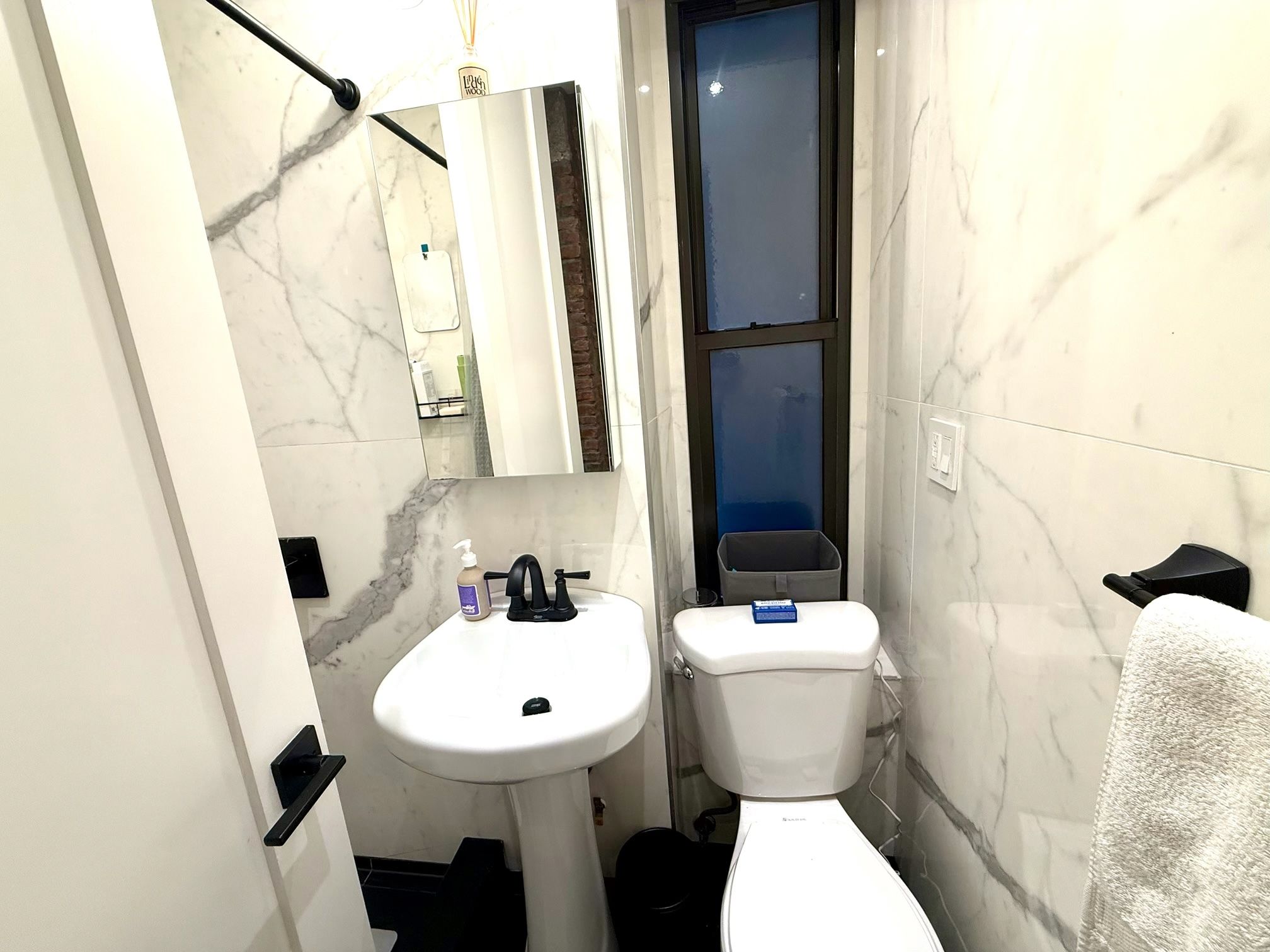 Un baño pequeño con un lavabo blanco, un inodoro y un espejo.