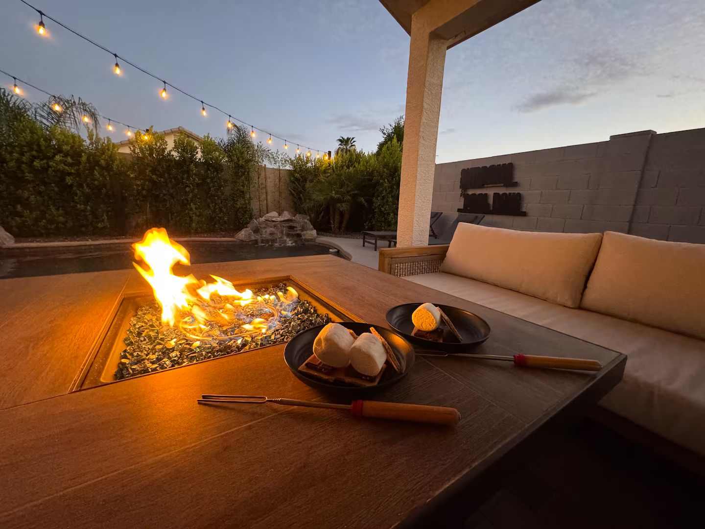 Un espace extérieur aménagé avec un foyer, un barbecue et un coin repas.