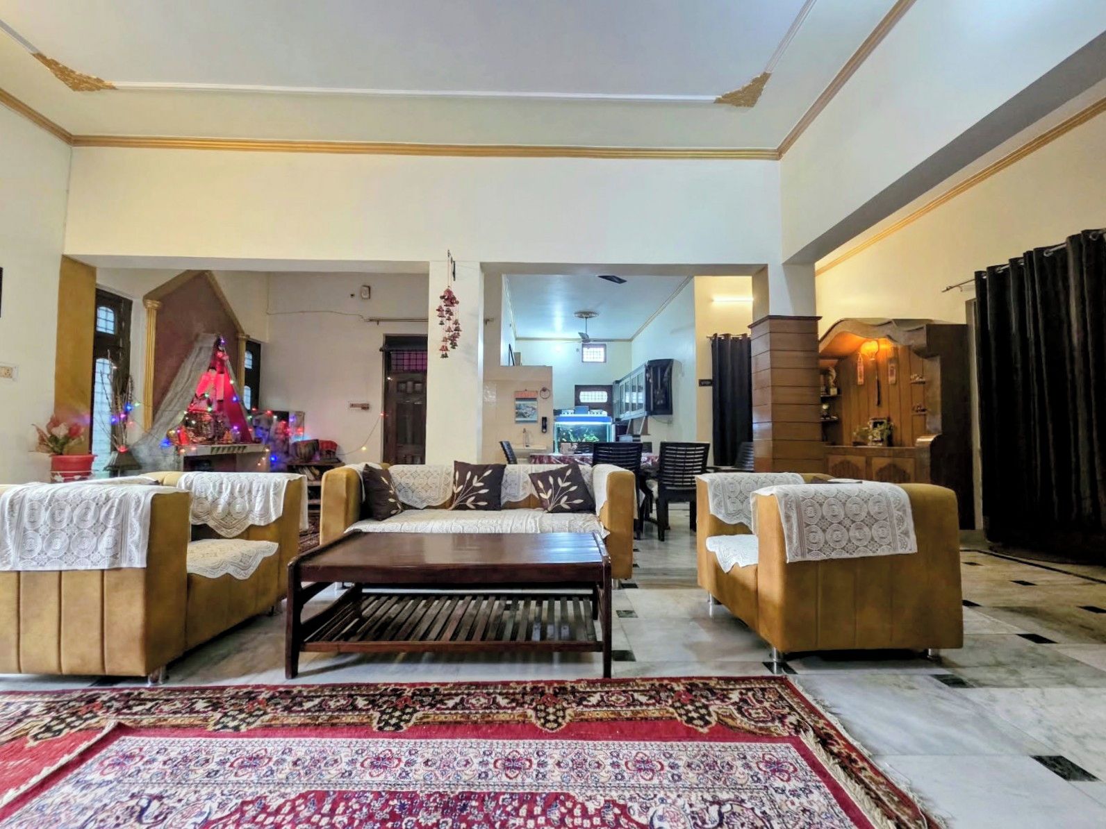 A spacious living room with a sofa set, a coffee table, and a patterned rug.