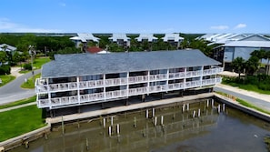 Un bâtiment situé au bord de l’eau, doté de nombreux balcons, d’un toit plat et d’une jetée qui s’avance dans l’eau.