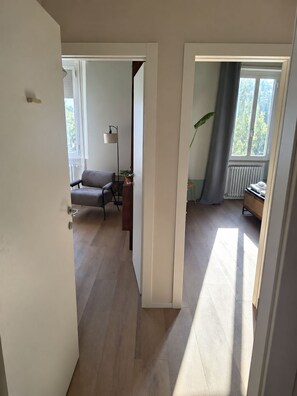 A room with a sofa, a lamp, a radiator, and a window with curtains. - Your stay in Bologna, just a stone's throw from Sant'Orsola, the city center, and the fairgrounds (Bologna)